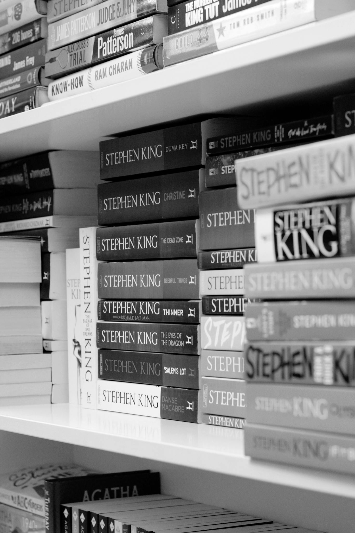 A detailed black and white bookshelf with Stephen King novels prominently displayed.