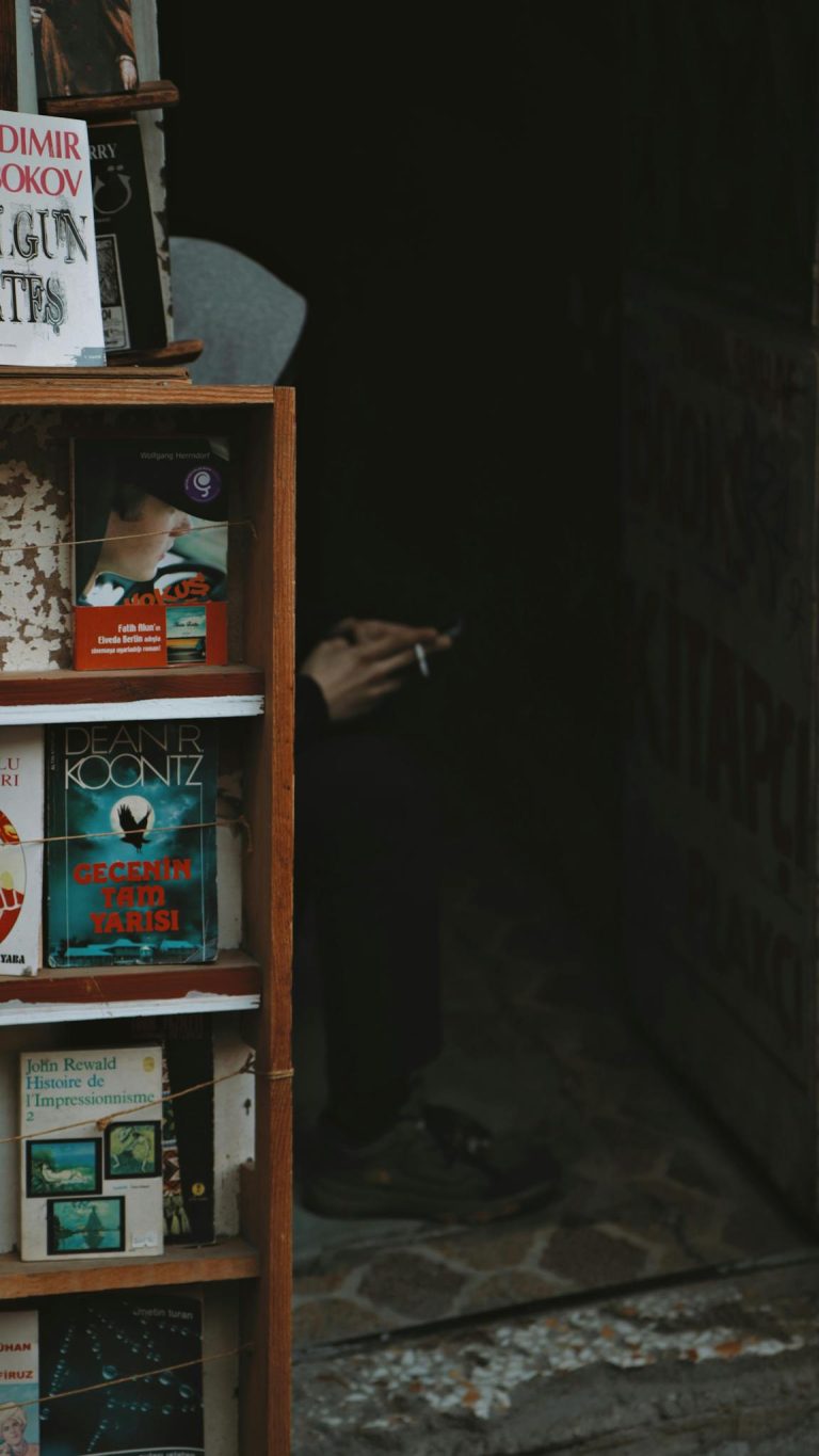 An inviting street bookstall with a smoker, displaying various books for sale.